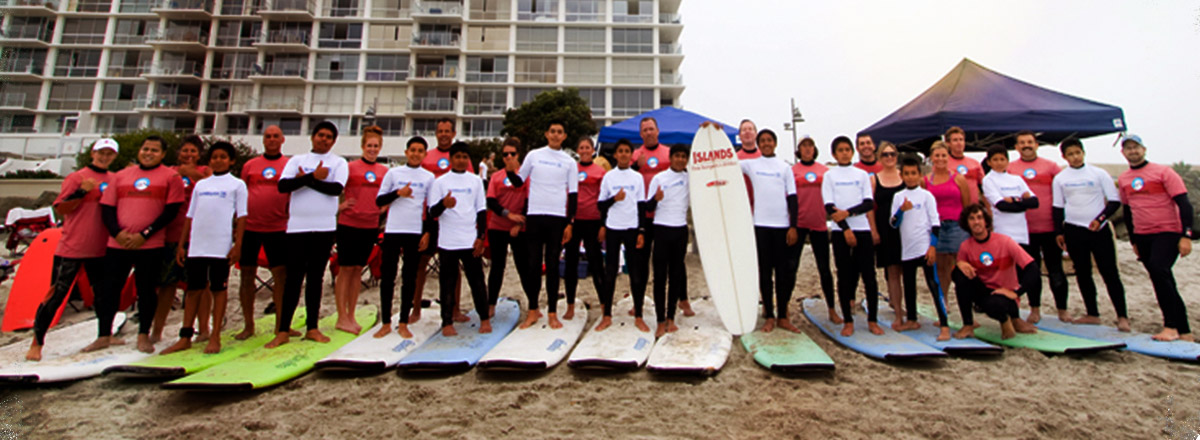 Group of children standing of surf boards at the beach